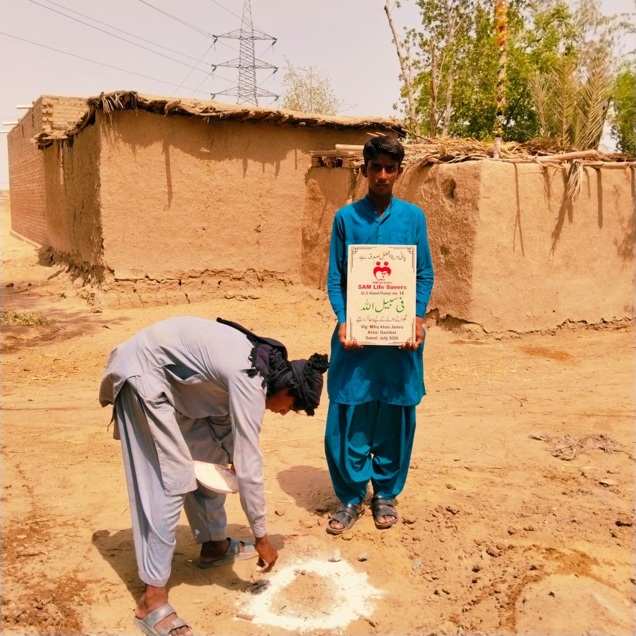 Volunteer marking the installation site for a donated hand pump in a rural village of Tharparkar, Pakistan, to provide clean drinking water to local families.